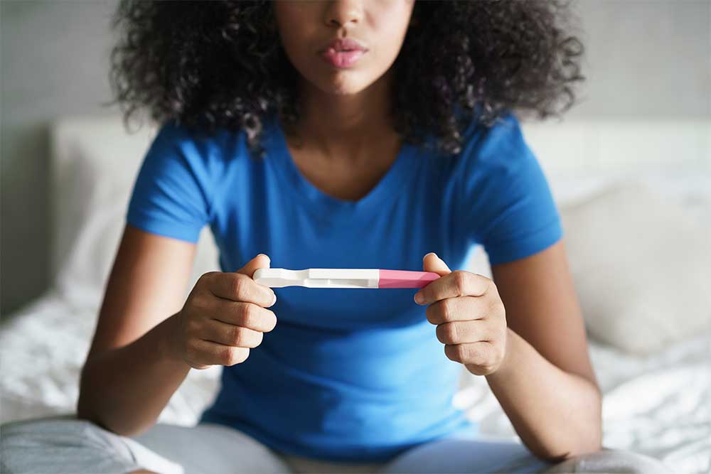 Junge Frau betrachtet einen Schwangerschaftstest